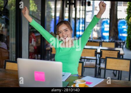 Asian  businesswomen Success and winning concept - happy team with raised up hands celebrating the breakthrough and achievements Stock Photo