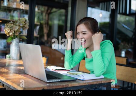 Asian  businesswomen Success and winning concept - happy team with raised up hands celebrating the breakthrough and achievements Stock Photo