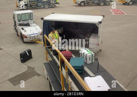 Airport baggage handler unload bags from an aircraft at Chicago O’Hare airport, USA Stock Photo