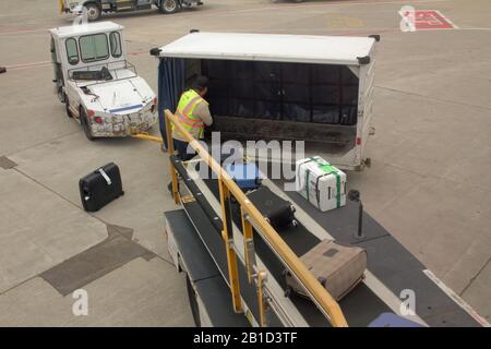 Airport baggage handler unload bags from an aircraft at Chicago O’Hare airport, USA Stock Photo