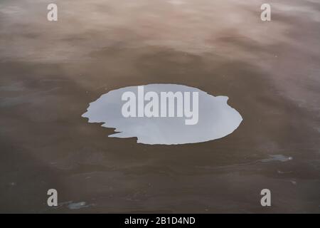 Pollution from a colored oil stain on the water surface Stock Photo