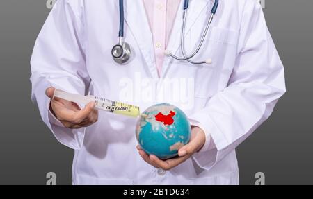 doctor in medical gown using an antiviral vaccine syringe on the red China map on the globe in hand. outbreak situation of Coronavirus 2019 infection Stock Photo