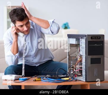 The angry customer trying to repair computer with phone support Stock Photo