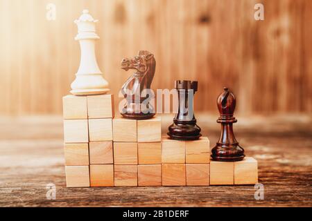 Chees pieces on a stair building with wooden blocks, metaphoring hierarchy, ranking, teamwork and strategy in business concept Stock Photo