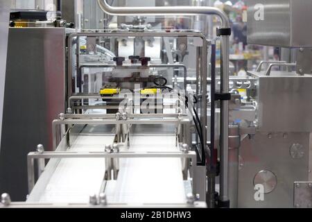 A fragment of a dairy factory. Dairy factory. Tape of delivery of finished packaged products. Conveyor in the dairy industry. Factory production, indu Stock Photo