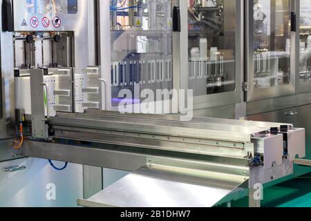 A fragment of a dairy factory. Dairy factory. Tape of delivery of finished packaged products. Conveyor in the dairy industry. Factory production, indu Stock Photo