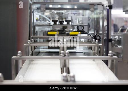 A fragment of a dairy factory. Dairy factory. Tape of delivery of finished packaged products. Conveyor in the dairy industry. Factory production, indu Stock Photo