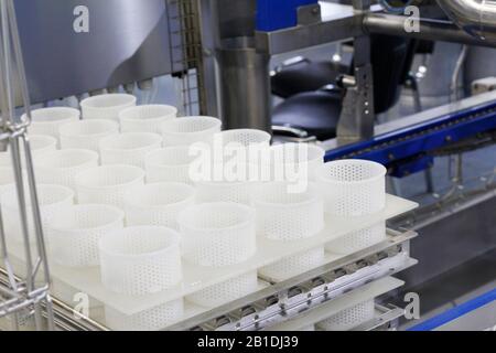 A fragment of a dairy factory. Dairy factory. Tape of delivery of finished packaged products. Conveyor in the dairy industry. Factory production, indu Stock Photo