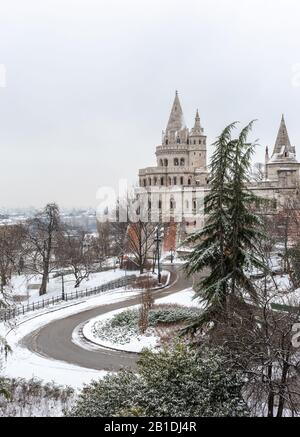 Budapest, Hungary - The north towers of the Fisherman's Bastion with pine trees on a snowy winter day Stock Photo