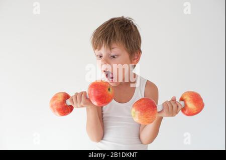 strong little boy in white tank top showing muscles with smile on his face  Stock Photo - Alamy