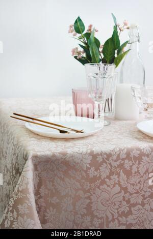 festive table setting with plates and cutlery, bright interior. Stock Photo