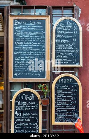 Typical menu written on blackboard outside Italian restaurant in Rome, Italy Stock Photo