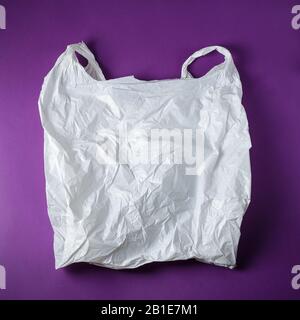 Square photo of the White Wrinkled Plastic Bag On Purple Background Stock Photo