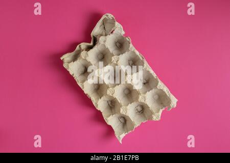 Empty Paper tray of eggs on bright pink background Stock Photo