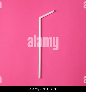 One white plastic straw on pink background. Plastic pollution. Environmental concept Stock Photo