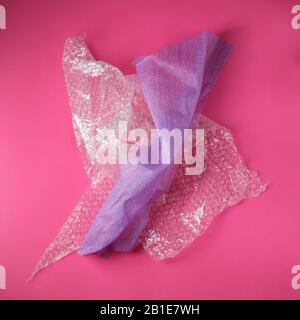 Plastic Bubble and Foam Cushioning Wrap on pink background Stock Photo