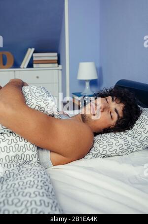 Man sleeping in bed at home Stock Photo