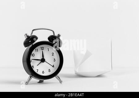 Paper boat with vintage black alarm clock on a white bakground Stock Photo