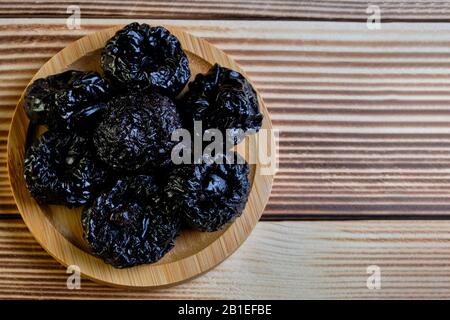 Dried prunes at weathered wooden background. Stock Photo
