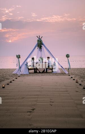 A romantic private beach dinner with candles at sunset with beautiful ...