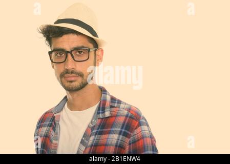 Studio shot of young Persian man wearing eyeglasses and hat Stock Photo