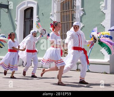 Litter of Huehues in traditional Mexican costumes at Tlaxcala Carnival, White dressed with feather hat in couples dancing  Tlaxcala, Mexico, Stock Photo