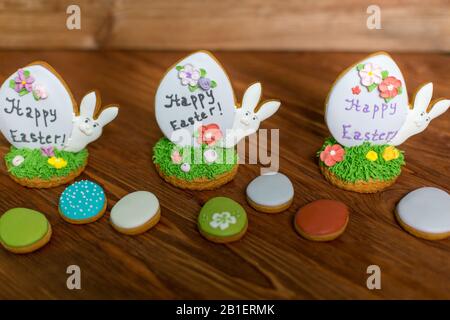 Colorful easter rabbits and eggs cookies on wooden background. Festive decoration. Happy Easter. Stock Photo