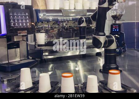 Robotic arm preparing coffee in coffee machine Stock Photo