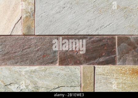 a beautiful detailed tan brown rust block cut slate rock wall close-up Stock Photo