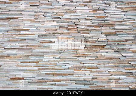 tan brown grey orange thin cut slate rock wall from a distance view Stock Photo