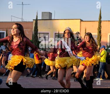 Group of man in drag dancing part of a Litter of Huehues ( hombres con hombres ) in Mexican costumes at Tlaxcala Carnival. Stock Photo