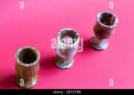 Three beautiful colorful elegant onyx glasses against trendy bright red background Stock Photo