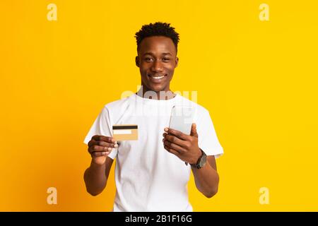 Young handsome african man making transaction online Stock Photo