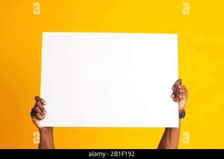African american hands holding big banner white sheet of paper Stock Photo