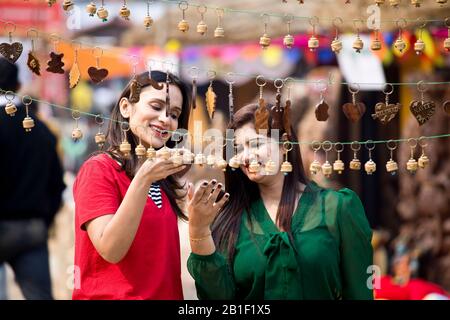 Two women shopping for necklace and earrings at street market Stock Photo