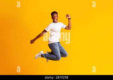 Young african man jumping as crazy, carefree, celebrating victory Stock Photo