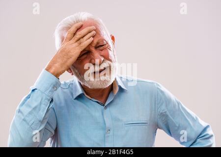 Portrait of senior man who is having headache. Stock Photo