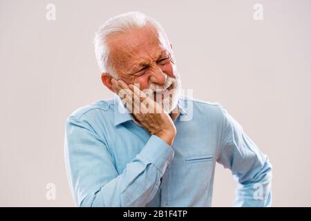 Portrait of senior man who is having toothache. Stock Photo