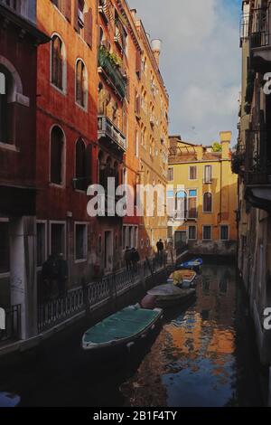 A view along Rio de Ca' Granzoni, a charming stroll through a unique iron lace balustrade canal-side street in late afternoon light Venice Italy Stock Photo