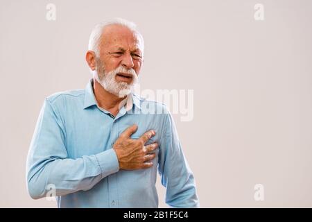 Portrait of senior man who is having pain in his chest. Stock Photo