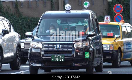 Tokyo, Japan. 17th Feb, 2020. A taxi driver wearing a face mask drives in Shinjuku, Tokyo, Japan, Feb. 17, 2020. TO GO WITH 'Roundup: Japan adopts basic policy to combat novel coronavirus spread' Credit: Guo Wei/Xinhua/Alamy Live News Stock Photo