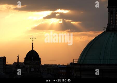 Church domes in morning light through clouds with a silhouette of the domes of Chiesa di Sant'Alessandro in Zebedia, Milan city Stock Photo