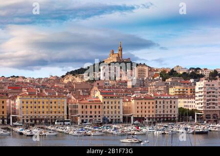 The old Vieux Port and Basilica Notre Dame de la Garde in the historical city center of Marseilles on sunny day, France Stock Photo