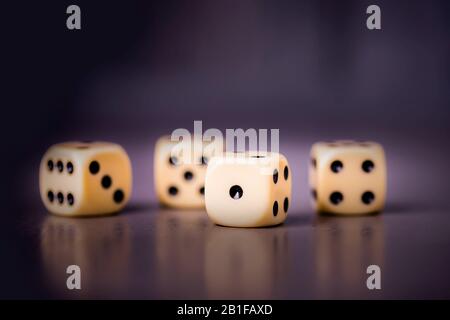 Four dices on a dark purple violet background, copy space Stock Photo