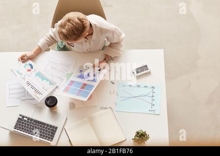 Above view background of modern businesswoman holding data charts while sitting at table, copy space Stock Photo