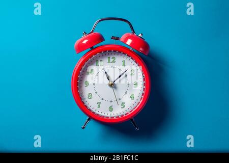Red alarm clock on the color background. Stock Photo