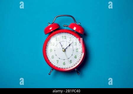 Red alarm clock on the color background. Stock Photo