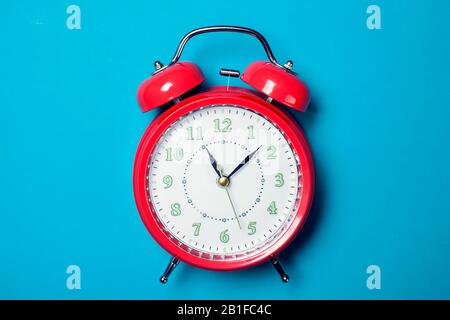 Red alarm clock on the color background. Stock Photo