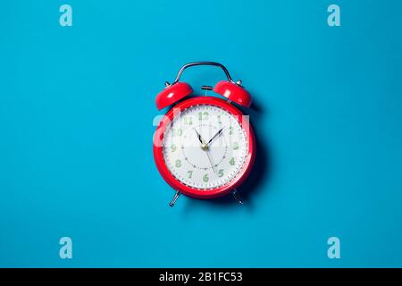 Red alarm clock on the color background. Stock Photo