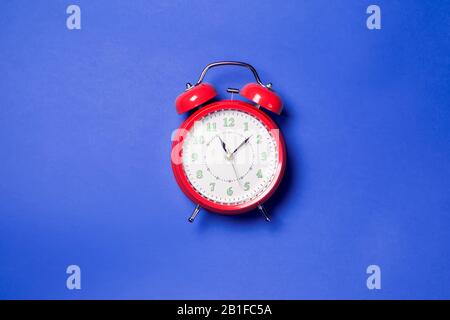 Red alarm clock on the color background. Stock Photo